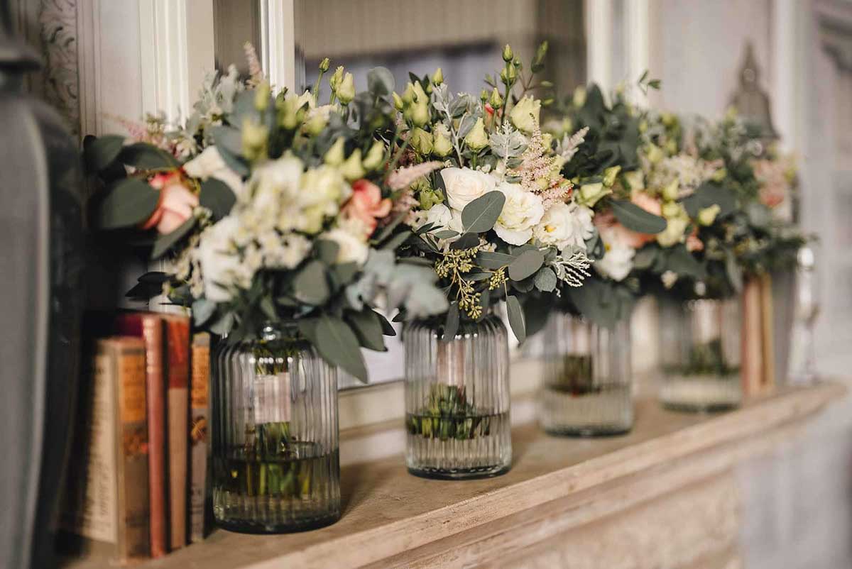 Flowers in glass lanterns on side